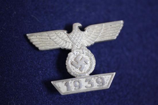 A collection of various German Third Reich cap badges, cloth badges and pins